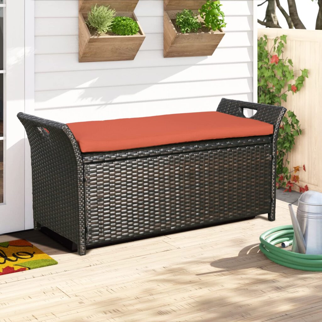 black wicker storage bench with an orange cushion
