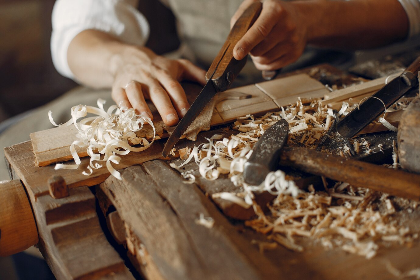 craftsman uses a handsaw to shape wood
