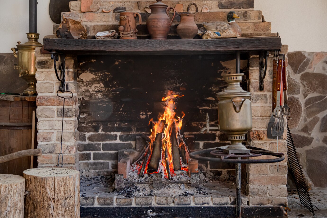 rustic fireplace with a roaring fire, surrounded by brick