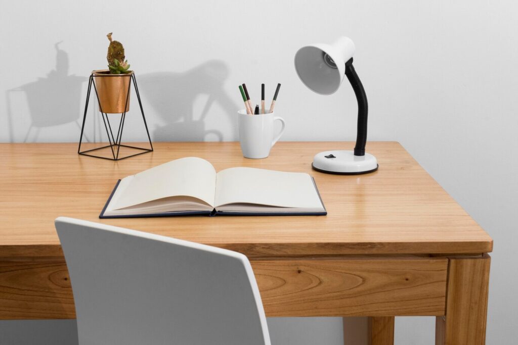 wooden desk features an open notebook