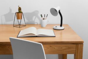 wooden desk features an open notebook