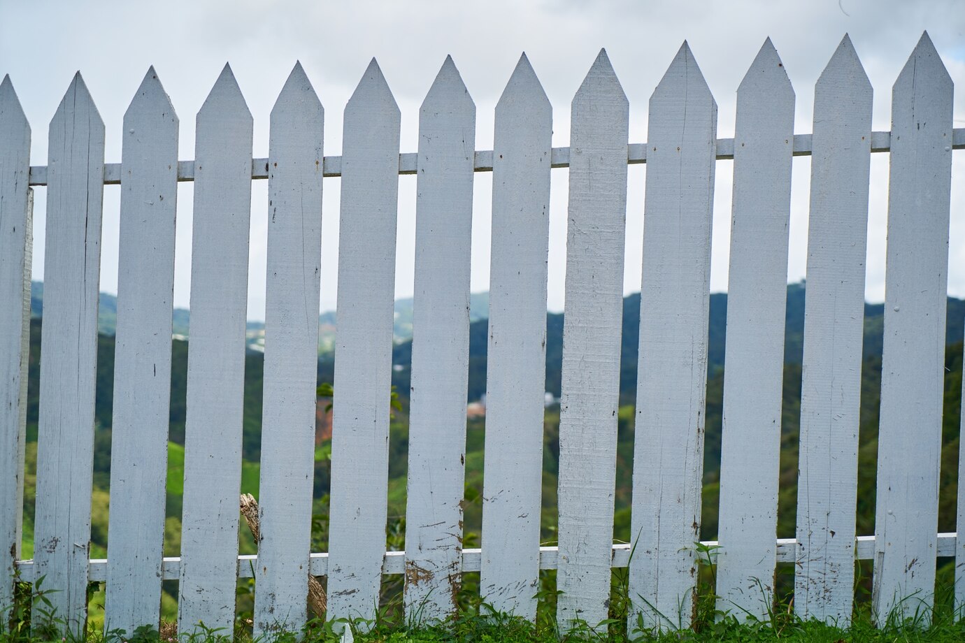 white picket fence with pointed tops standing