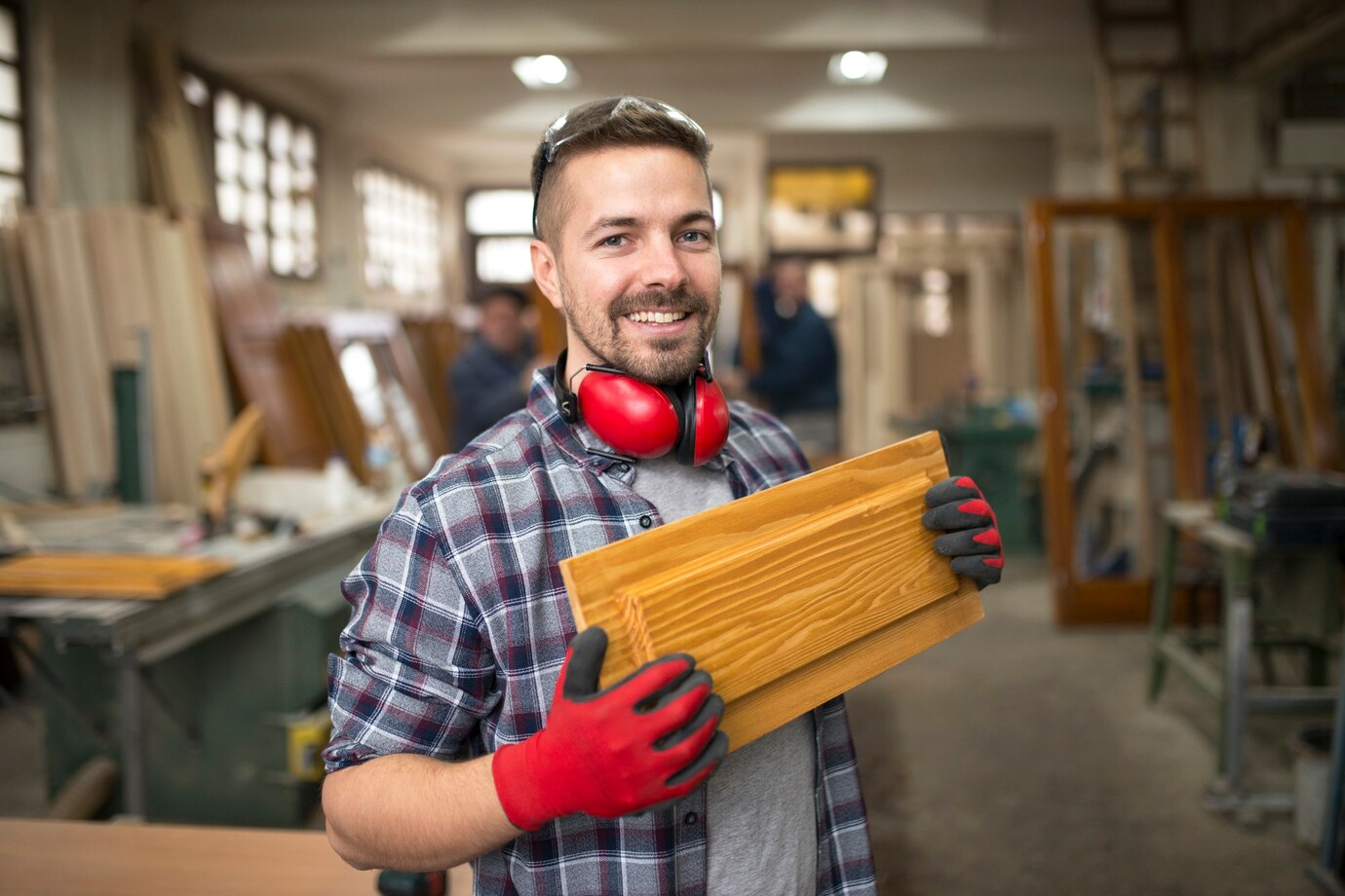 Smiling man holding wooden plank